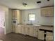 Partially renovated kitchen featuring off-white cabinets, granite counters, new appliances, and new flooring at 2131 Barnett St, Lancaster, SC 29720