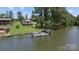 Lakeside property with boat dock, personal watercraft, and a charming home, nestled amidst mature trees and sprawling lawns at 281 Emerald Shores Rd, Mount Gilead, NC 27306