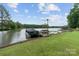 Lush backyard with a boat dock, and fire pit on the lakefront property with mature trees at 281 Emerald Shores Rd, Mount Gilead, NC 27306