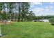 Beautiful waterfront backyard featuring a deck, a playhouse, and mature trees at 281 Emerald Shores Rd, Mount Gilead, NC 27306