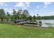 Picturesque dock with a fire pit and boat lifts on a serene lake at 281 Emerald Shores Rd, Mount Gilead, NC 27306