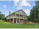 Expansive two-story home featuring a charming wooden deck, a spacious lawn, and inviting outdoor spaces for leisure and enjoyment at 281 Emerald Shores Rd, Mount Gilead, NC 27306