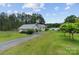 Quaint property featuring a charming house and separate garage or workshop, all surrounded by lush greenery and a serene waterfront at 281 Emerald Shores Rd, Mount Gilead, NC 27306