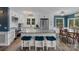 Bright kitchen boasts an island with seating, stainless steel appliances, white cabinetry, and an adjacent dining area at 281 Emerald Shores Rd, Mount Gilead, NC 27306