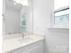 Clean and bright bathroom featuring a white vanity, large mirror, and a window that provides ample natural light at 2813 New Pineola Rd, Charlotte, NC 28208