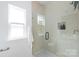 The glass shower with stylish tile, window, showerhead, and toiletry alcove in a modern and bright bathroom at 2813 New Pineola Rd, Charlotte, NC 28208