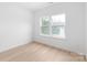 Bright bedroom with light wood flooring features a large window providing natural light and ample wall space at 2813 New Pineola Rd, Charlotte, NC 28208