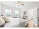 Bright primary bedroom features two windows, light wood floors, a ceiling fan, and ensuite access to a bathroom at 2813 New Pineola Rd, Charlotte, NC 28208