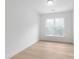 Bright bedroom featuring light wood floors, a large window, and neutral walls creating a serene atmosphere at 2813 New Pineola Rd, Charlotte, NC 28208