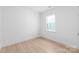 Bright bedroom featuring light wood floors, a large window, and neutral walls creating a serene atmosphere at 2813 New Pineola Rd, Charlotte, NC 28208