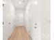 Bright hallway featuring white walls, a light wood floor, and multiple doors, creating a seamless transition throughout the home at 2813 New Pineola Rd, Charlotte, NC 28208