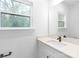 Bathroom featuring a white vanity with a quartz countertop, a mirror, and a window at 2815 New Pineola Rd, Charlotte, NC 28208