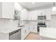 Well-lit kitchen featuring white cabinets, quartz countertops, a stainless steel dishwasher and a cooktop at 2815 New Pineola Rd, Charlotte, NC 28208