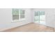 Living room featuring hardwood floors, white walls, and a sliding glass door leading to the backyard at 2815 New Pineola Rd, Charlotte, NC 28208