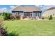 A serene backyard with a covered patio, lush green lawn, and tasteful landscaping at 3103 Oliver Stanley Trl, Lancaster, SC 29720
