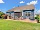 A backyard showing a well-manicured lawn and a cozy patio with a built-in grill and screen porch at 3103 Oliver Stanley Trl, Lancaster, SC 29720