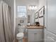 Cozy bathroom with neutral tones, featuring a toilet, vanity with storage, and a window with blinds at 3103 Oliver Stanley Trl, Lancaster, SC 29720