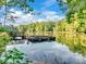 Community dock with a wooden pier on a reflective lake surrounded by lush trees at 3103 Oliver Stanley Trl, Lancaster, SC 29720