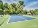 Brightly painted pickleball court with a green and blue surface in a fenced and landscaped community at 3103 Oliver Stanley Trl, Lancaster, SC 29720