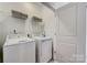 Bright laundry room with a front-load washer and dryer, plus shelving for organized storage at 3132 Stelfox St, Charlotte, NC 28262