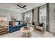 Bright living room features a blue couch, neutral chairs, a ceiling fan, and a sliding glass door at 3132 Stelfox St, Charlotte, NC 28262
