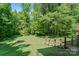 Spacious backyard featuring lush greenery, fire pit and wooden steps leading up to the home at 335 Bob White Run, Salisbury, NC 28147