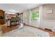Bright dining area with wainscoting, wooden floors, a large window and an adjacent breakfast bar at 335 Bob White Run, Salisbury, NC 28147