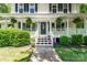 Inviting front porch with white railings, hanging plants, and pink potted flowers on the steps at 335 Bob White Run, Salisbury, NC 28147