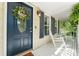 Inviting front porch with rocking chairs, decorative wreath, and blue door with side-light windows at 335 Bob White Run, Salisbury, NC 28147