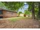 Expansive backyard features a brick home, a storage shed, and mature trees at 3828 Delgany Dr, Charlotte, NC 28215
