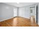 Bright bedroom features hardwood floors, light gray walls, and a door leading outside at 3828 Delgany Dr, Charlotte, NC 28215