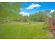 Expansive backyard featuring lush green lawn, mature trees, wooden fence, and inviting outdoor seating area with fire pit at 3864 Meadow Ridge Nw Dr, Concord, NC 28027