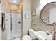 Bathroom features a white sink, toilet, framed artwork, and a glass-enclosed shower stall at 3864 Meadow Ridge Nw Dr, Concord, NC 28027