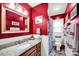 Red bathroom featuring a vanity with granite countertop and shower with nautical-themed shower curtain at 3864 Meadow Ridge Nw Dr, Concord, NC 28027
