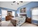 Bright bedroom with blue walls, wood furniture, coastal decor, and a ceiling fan at 3864 Meadow Ridge Nw Dr, Concord, NC 28027