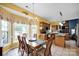 Bright dining room open to the kitchen featuring a wooden table, bay window, and neutral tile flooring at 3864 Meadow Ridge Nw Dr, Concord, NC 28027