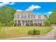 Charming two-story home with a manicured lawn, front porch, beautiful shrubbery, and classic architectural details at 3864 Meadow Ridge Nw Dr, Concord, NC 28027