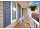 Cozy front porch with brick flooring, blue shutters, seating, and hanging plants, offering a relaxing outdoor space at 3864 Meadow Ridge Nw Dr, Concord, NC 28027