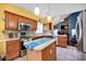 Modern kitchen with stainless steel appliances, wood cabinetry, and an island open to the living room at 3864 Meadow Ridge Nw Dr, Concord, NC 28027