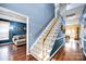 Elegant staircase with carpeted steps, a stained wood banister, and a view into the adjacent living spaces at 3864 Meadow Ridge Nw Dr, Concord, NC 28027