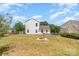 Grassy backyard featuring a fire pit, lawn, and a white two-story home in a suburban setting at 4002 Solomons Ct, Monroe, NC 28110