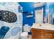 Bright blue bathroom features a unique patterned shower curtain, storage shelves, and a vanity at 4002 Solomons Ct, Monroe, NC 28110