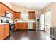 Bright kitchen features stainless steel refrigerator, wood cabinets, and wood flooring at 4002 Solomons Ct, Monroe, NC 28110
