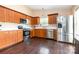 Modern kitchen with stainless steel appliances, hardwood floors, and wooden cabinets at 4002 Solomons Ct, Monroe, NC 28110
