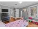 Bedroom with hardwood floors, a TV, closet, dresser, and a view into the bathroom at 402 School St, Rockwell, NC 28138