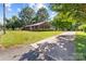 Well-maintained brick home with a lush green lawn, mature trees, and a long driveway at 402 School St, Rockwell, NC 28138