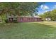 Well-manicured lawn of a brick home featuring a metal roof, dark shutters, and a quaint front porch at 402 School St, Rockwell, NC 28138