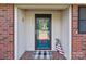 Inviting front porch featuring a decorative front door, brick accents, and a charming welcome sign at 402 School St, Rockwell, NC 28138