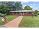 Charming brick home with a brick pathway and mailbox adorned with a North Carolina flag amid green lawns at 402 School St, Rockwell, NC 28138