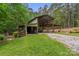 The gravel driveway leads to a barn with an open shelter, set amidst lush greenery at 4038 Forest Brook Dr, Edgemoor, SC 29712
